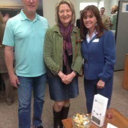 A man and two women are posing for a picture in an office