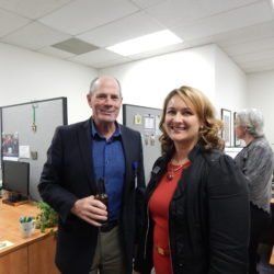 A man and a woman are standing next to each other in an office.