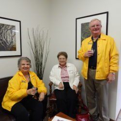 Three people in yellow jackets are posing for a picture