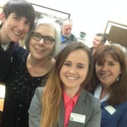 A group of people are posing for a picture together and smiling.