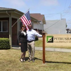 A man and a woman standing in front of a petrusha sign