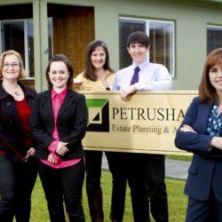 A group of people standing in front of a petrusha sign