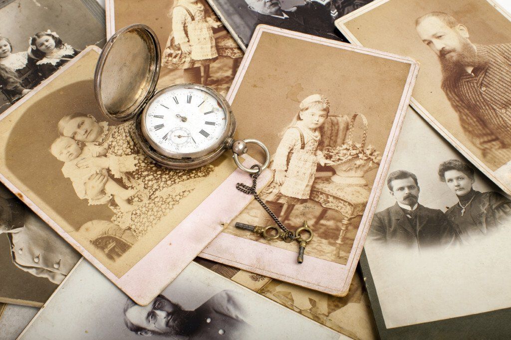 pocketwatch lying on top of old photographs