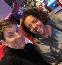 A man and a woman are posing for a picture in an amusement park.