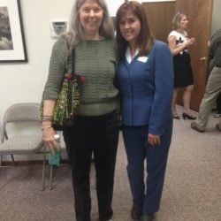 Two women are posing for a picture together in a room.