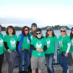A group of people wearing green shirts are posing for a picture.
