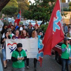 A group of people marching down a street holding flags