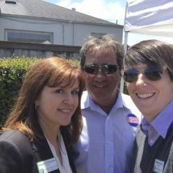 Three people are posing for a picture together and smiling.