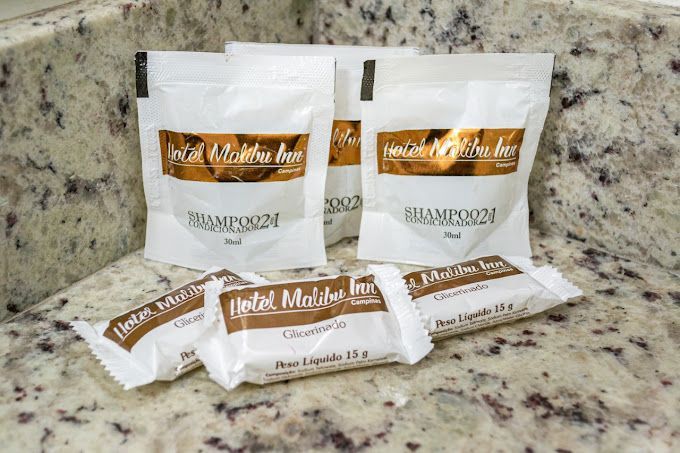 Um balcão de banheiro com um monte de sacolas de produtos de higiene pessoal-hotel-malibu-inn