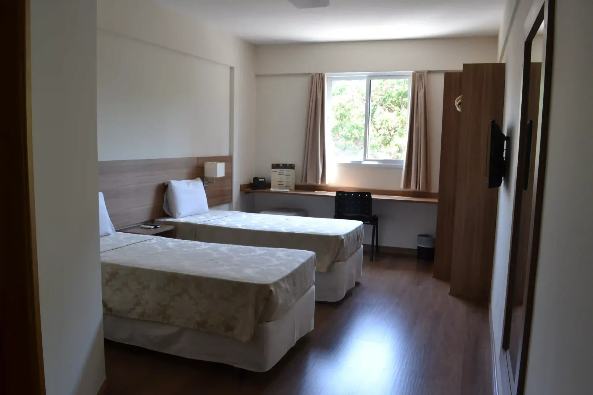 Um quarto de hotel com duas camas e uma janela-hotel-malibu-inn