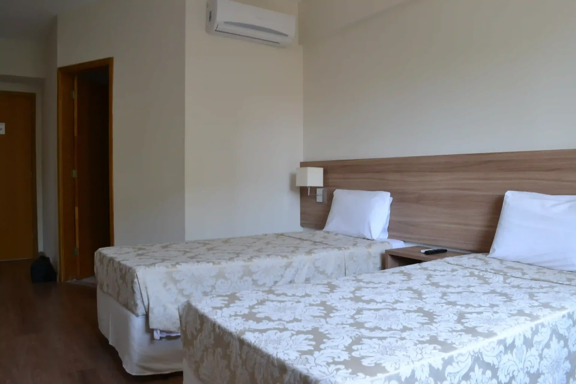 Um quarto de hotel com duas camas e uma cabeceira de madeira.-hotel-malibu-inn