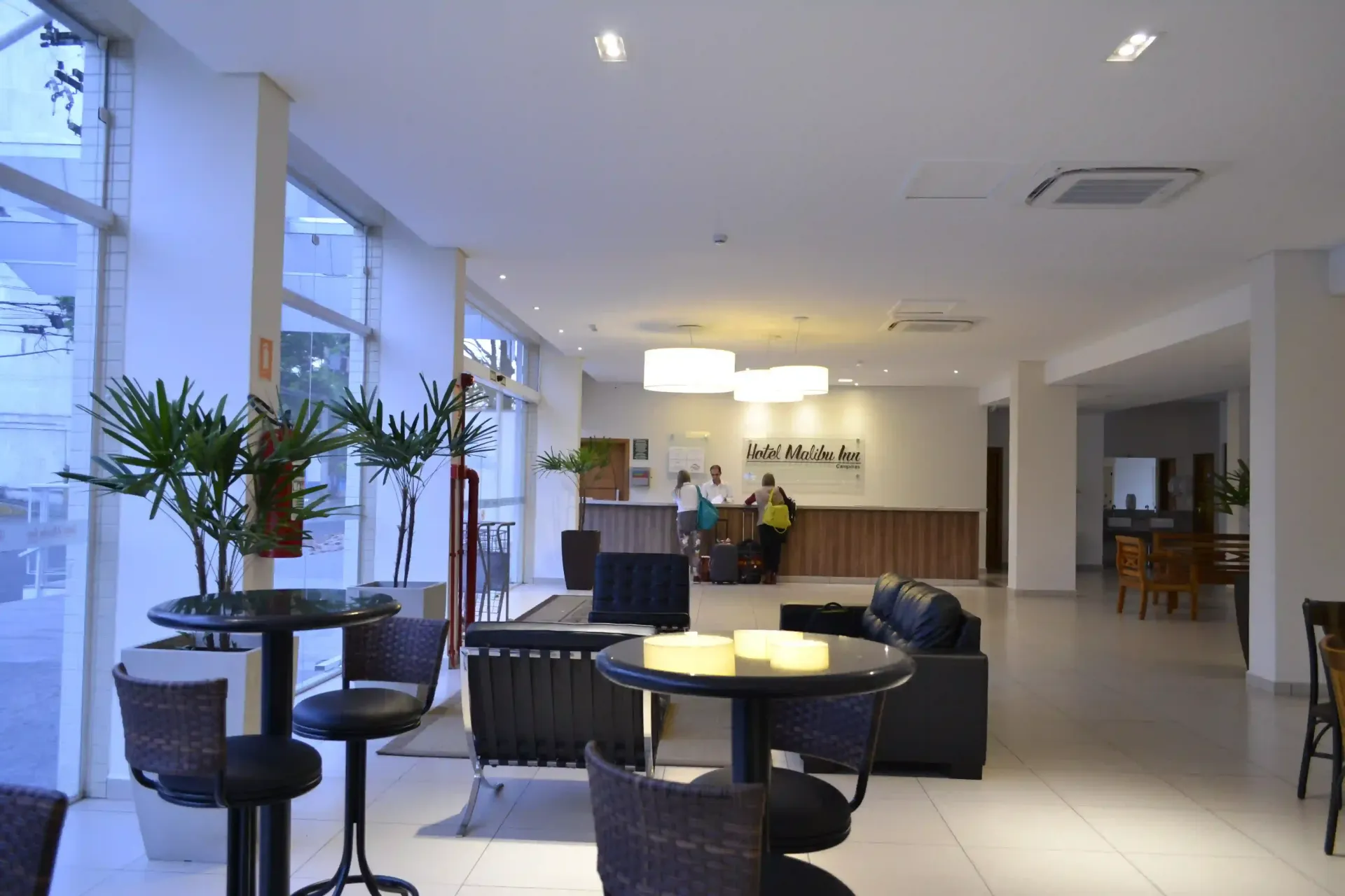 Um lobby de hotel com mesas e cadeiras e um balcão de recepção-hotel-malibu-inn