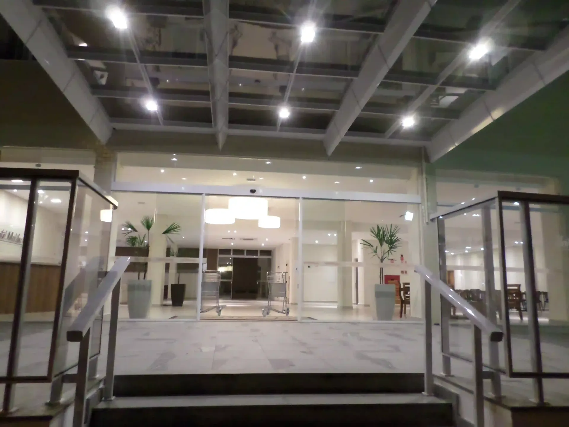 A entrada de um prédio com escadas e telhado de vidro-hotel-malibu-inn