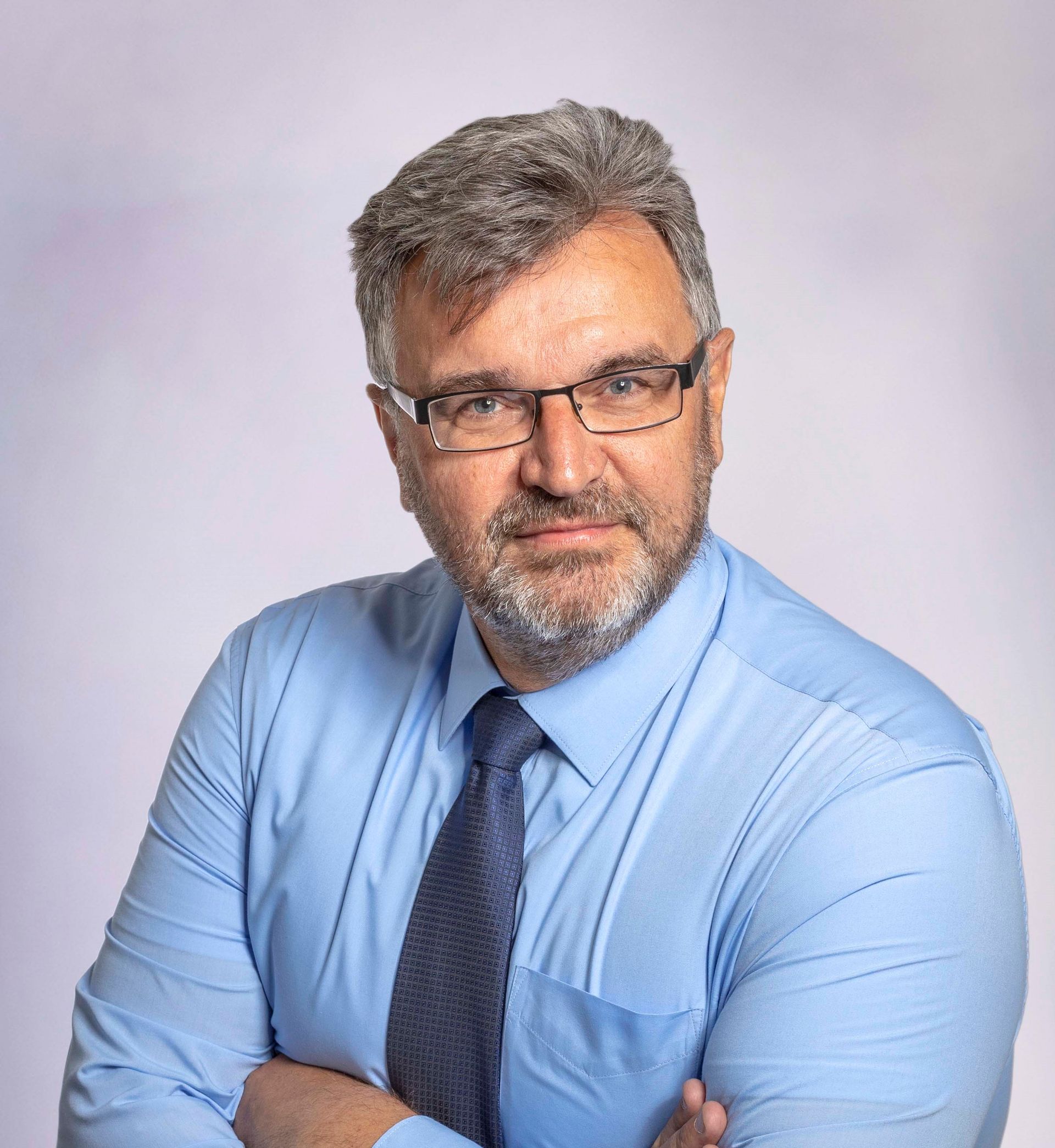 Porträtfoto von Dirk Haas, Experte für digitale Barrierefreiheit. Er trägt ein hellblaues Hemd und eine dunkle Krawatte und blickt direkt in die Kamera.
