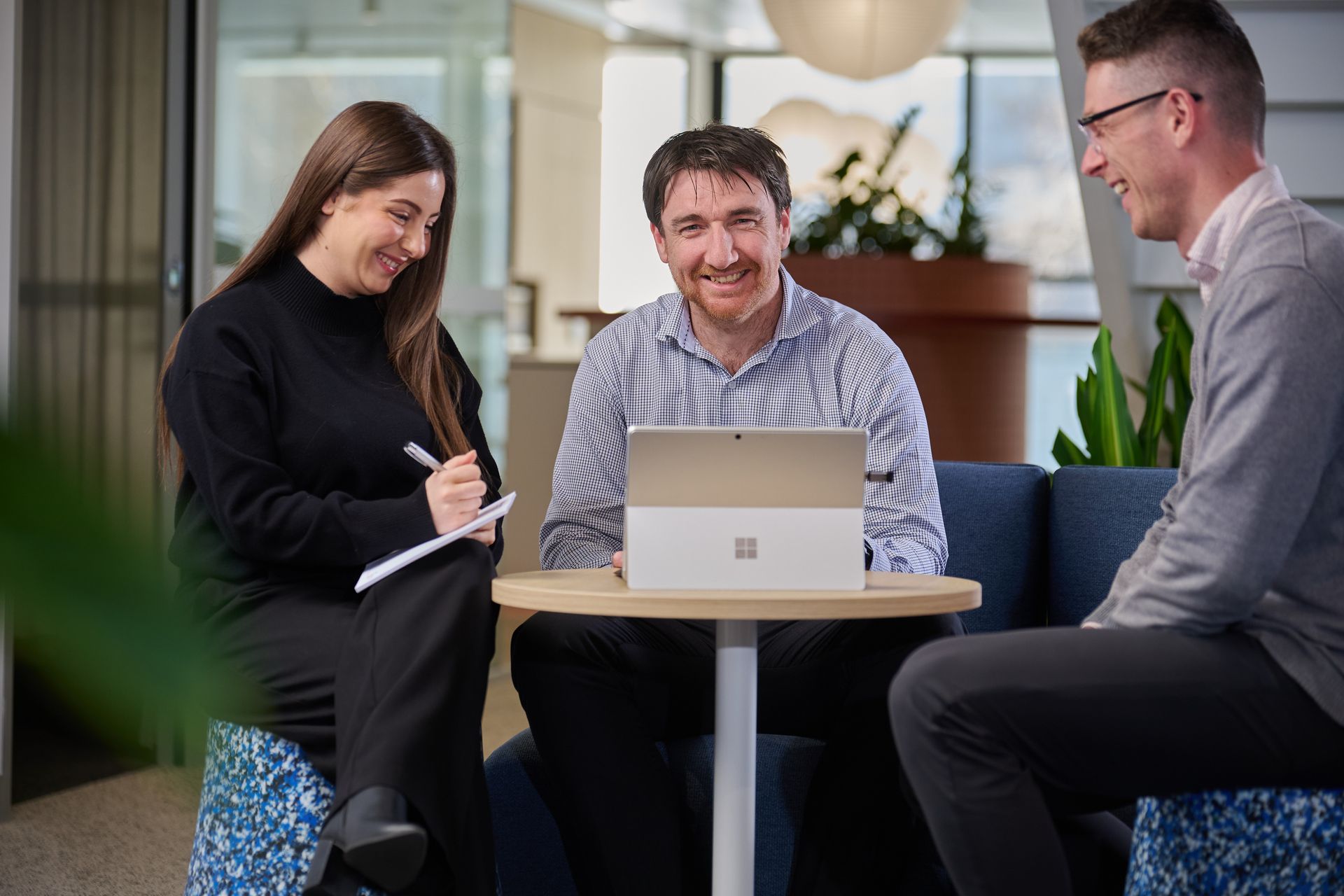Gavin Mitchell, partner, and Jade Giang, manager, are walking down a hallway and talking together in an office environment.