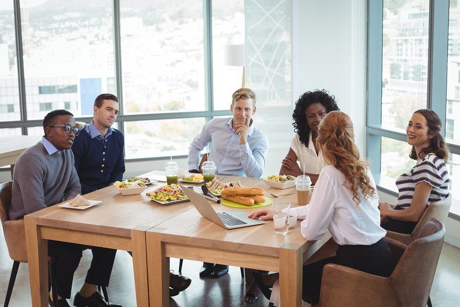 Group of people sitting around a table reviewing a computer screen.