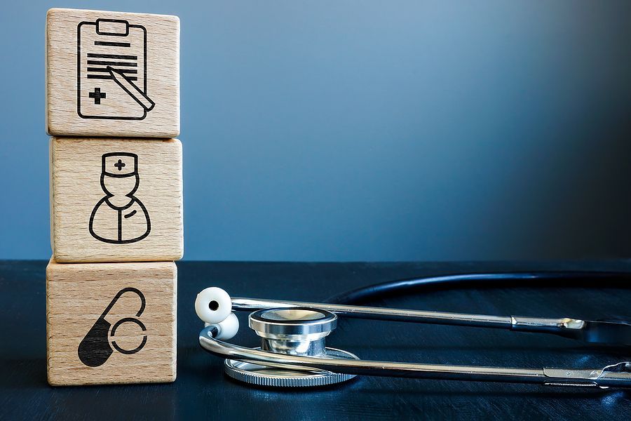 Building blocks with an image of a schedule/patient board, doctor and medicine pills.