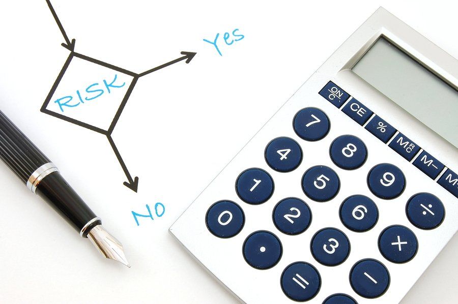 Written on paper RISK with arrows Yes or No and a calculator.