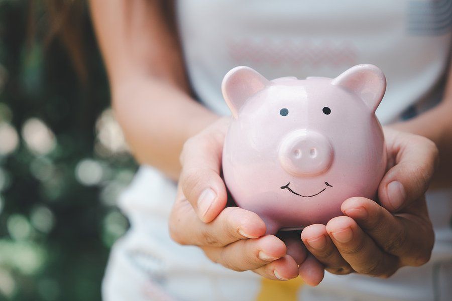 Woman holding a pink pig money box.