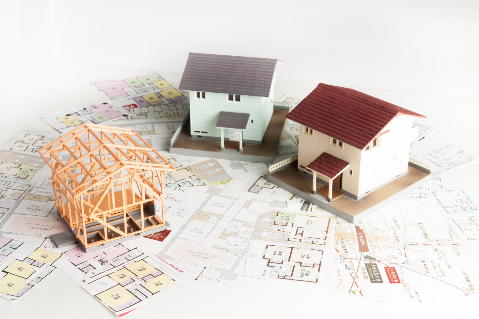 Three models of houses sitting on top of building plans.
