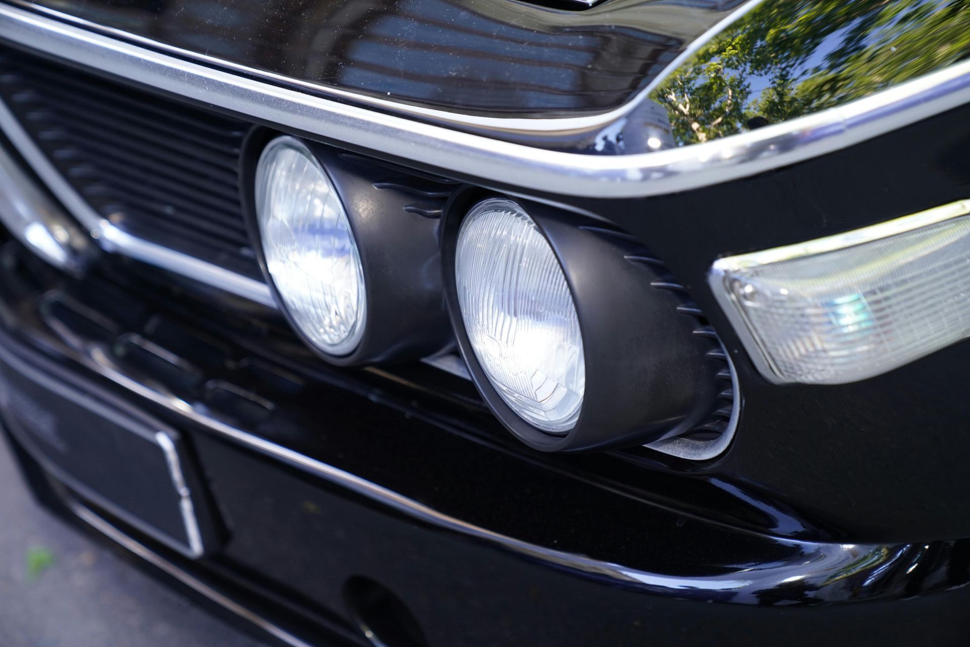 Person using a tool to manipulate a car door lock on a white car.