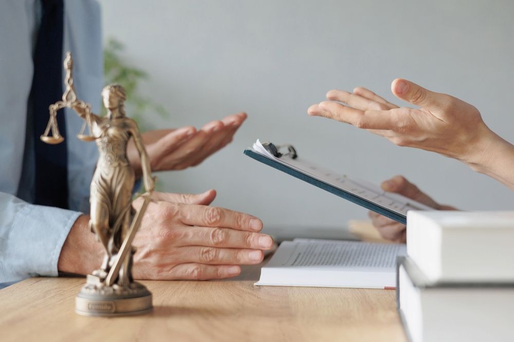 A Lawyer Explains a Document to a Client at a Wooden Desk — Hannaway Lawyers in Port Macquarie, NSW