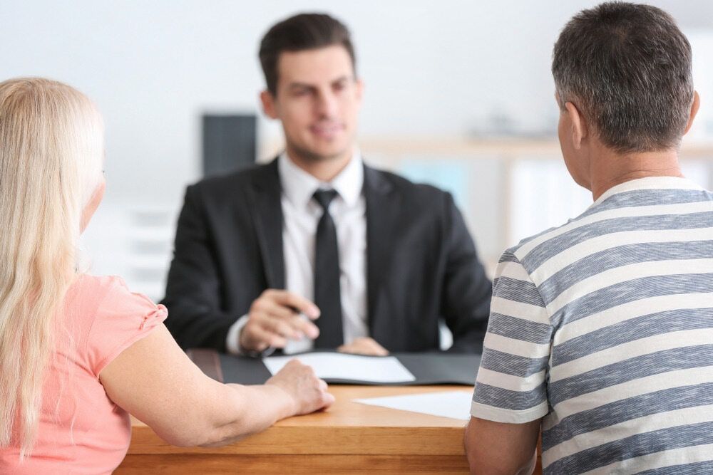 Couple Meeting With a Financial Advisor at a Desk, Discussing Documents — Hannaway Lawyers in Port Macquarie, NSW