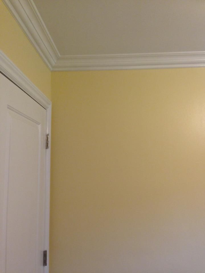 A room with yellow walls and a white door