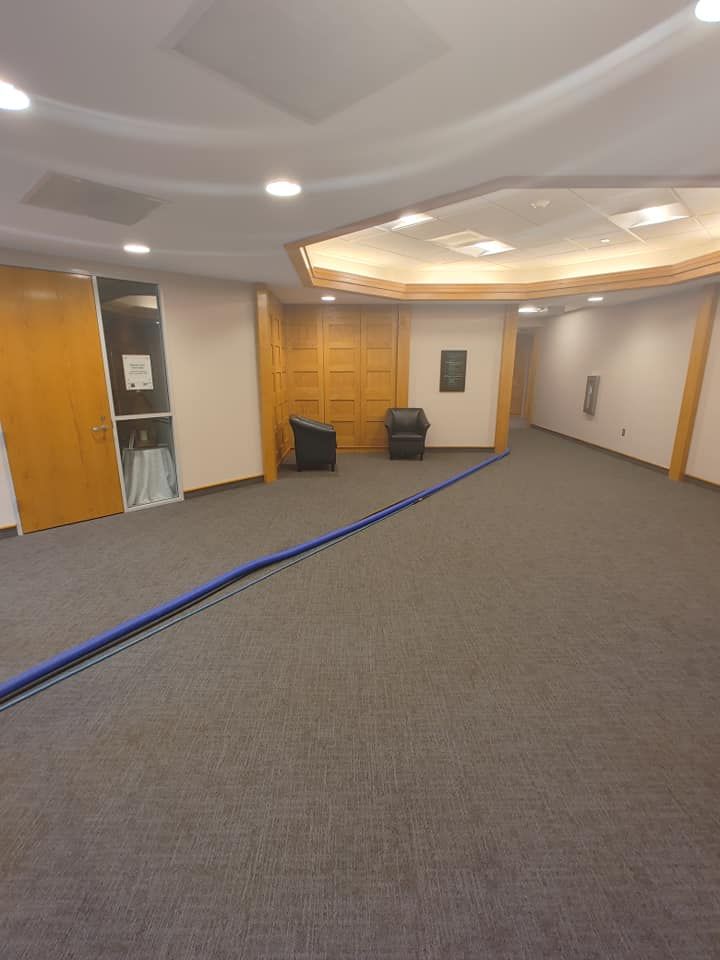 A large room with a carpeted floor and chairs in it.