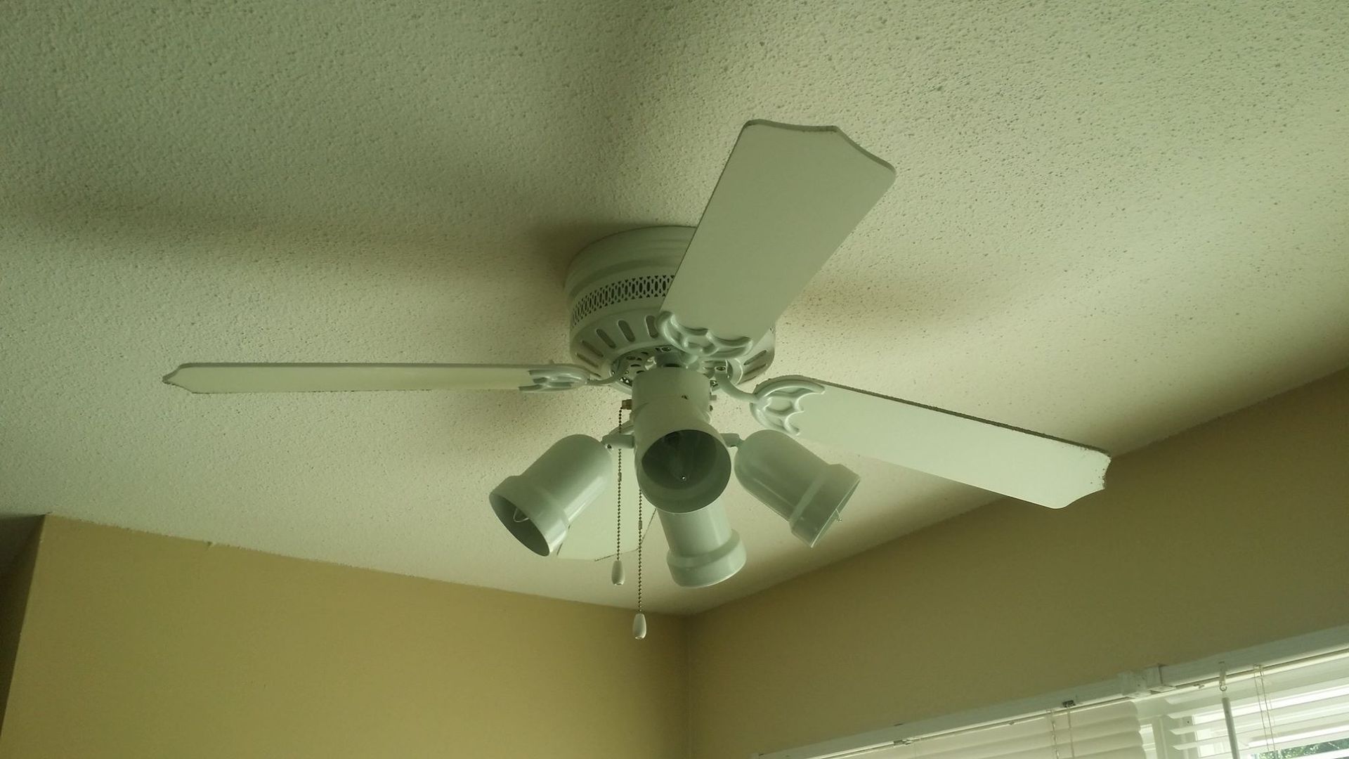 A white ceiling fan is hanging from the ceiling of a room
