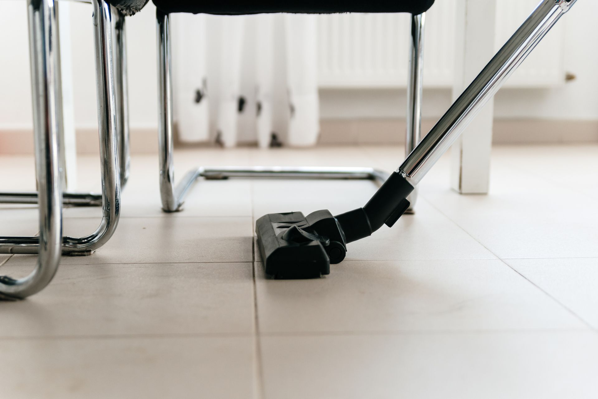 A vacuum cleaner is sitting on the floor next to a chair.