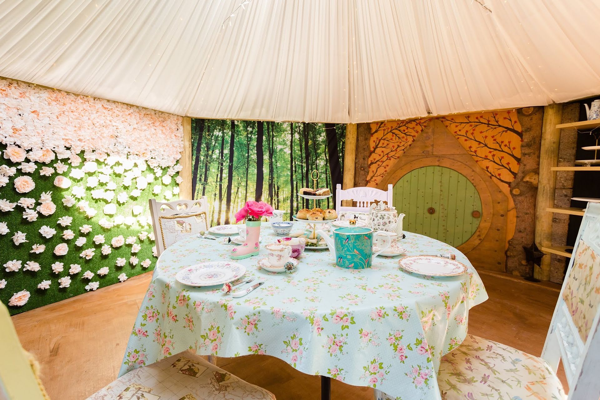 A round table with plates and cups on it under a tent.