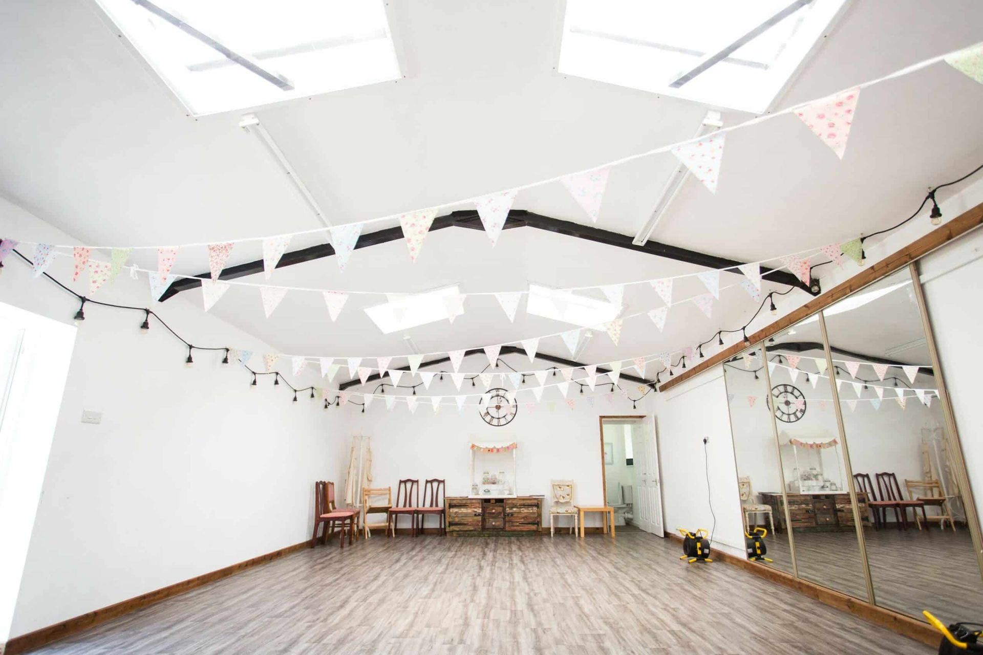 A large room with a mirror and flags hanging from the ceiling.