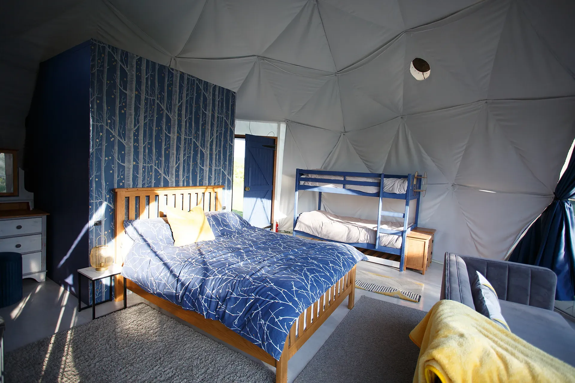 A bedroom with a bed and bunk beds in a dome.