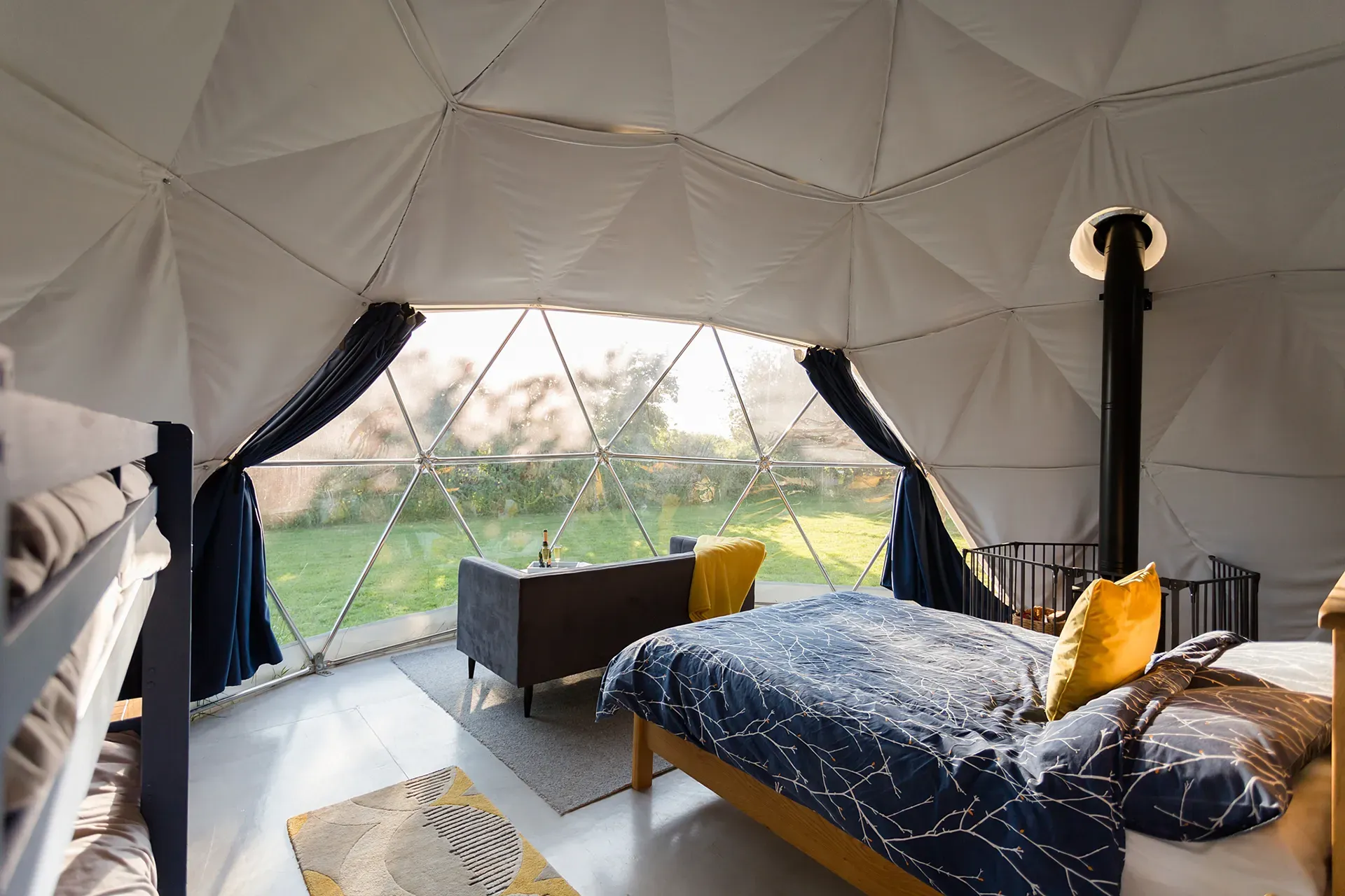 A bedroom in a dome with a bed and a couch.