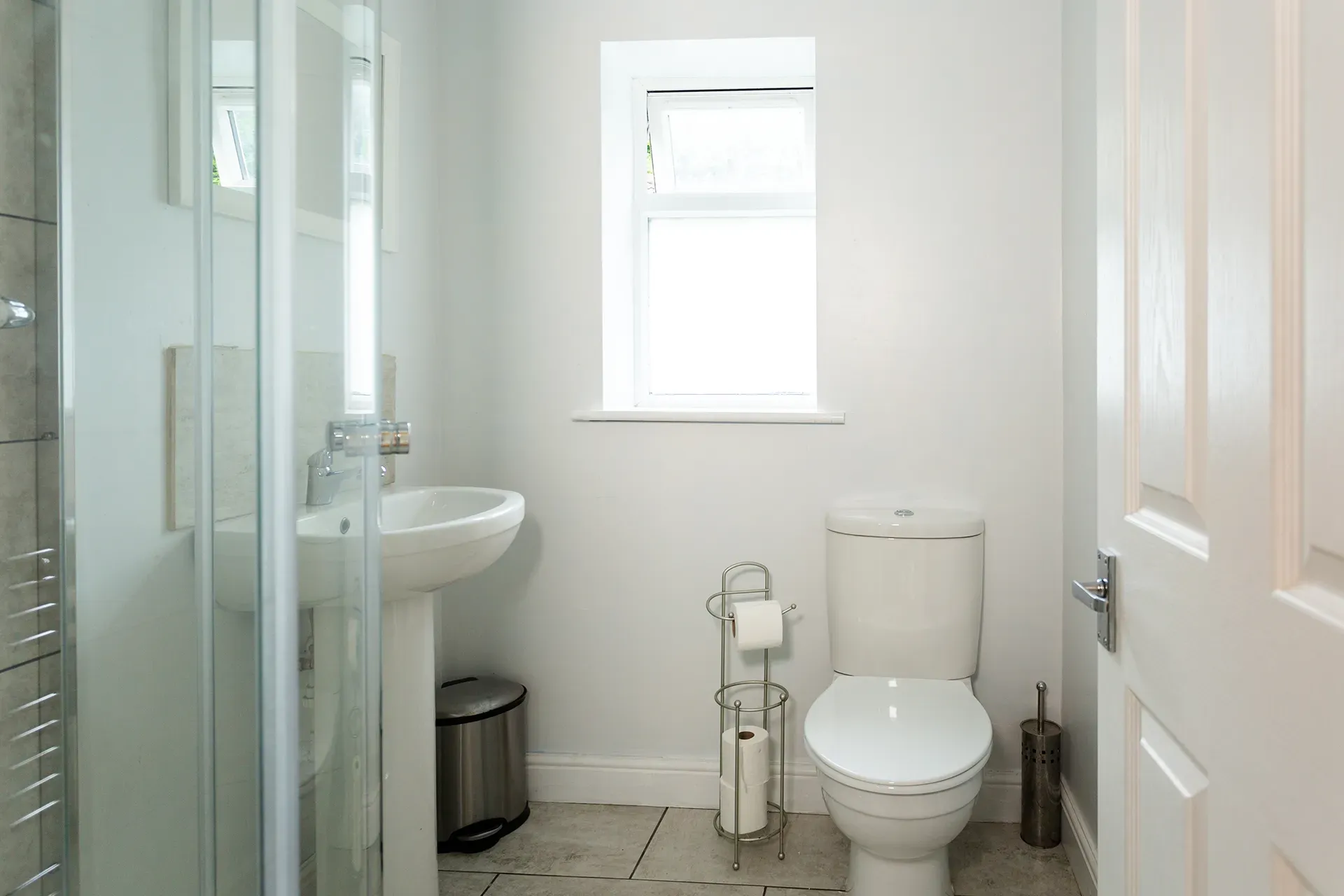 A bathroom with a toilet , sink , and shower.