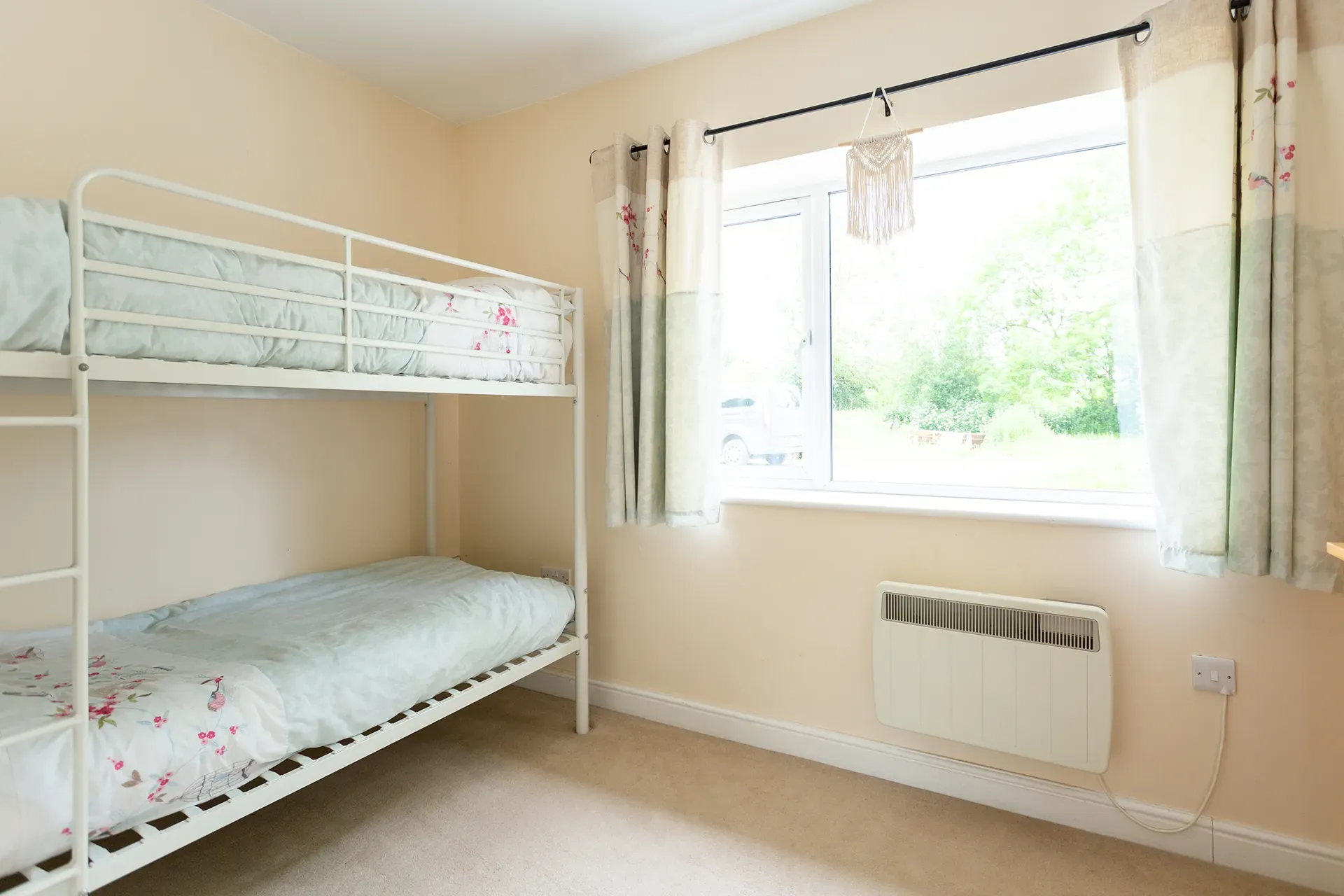 A bedroom with two bunk beds and a window.