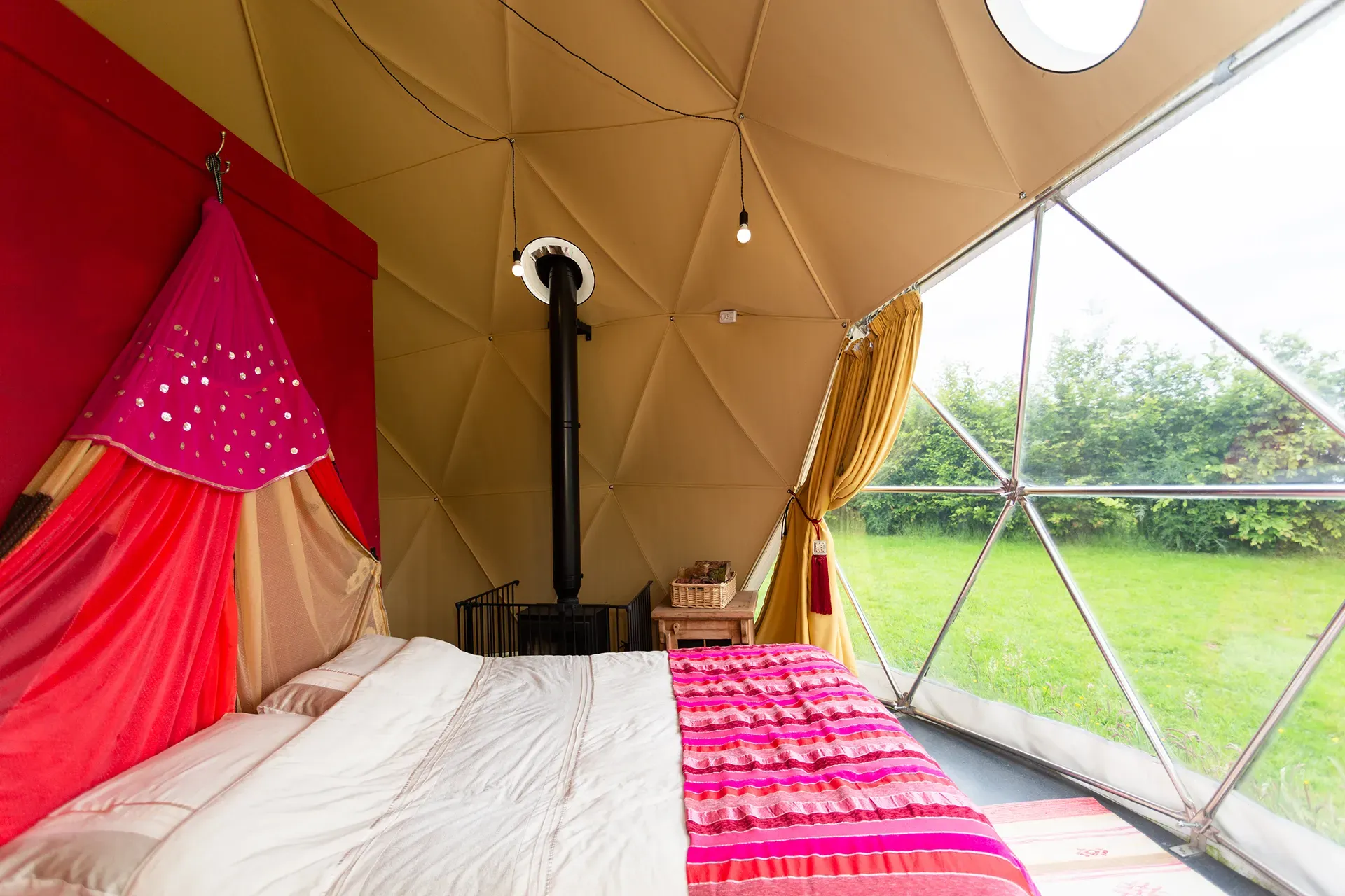 A bedroom in a dome with a bed and a canopy.