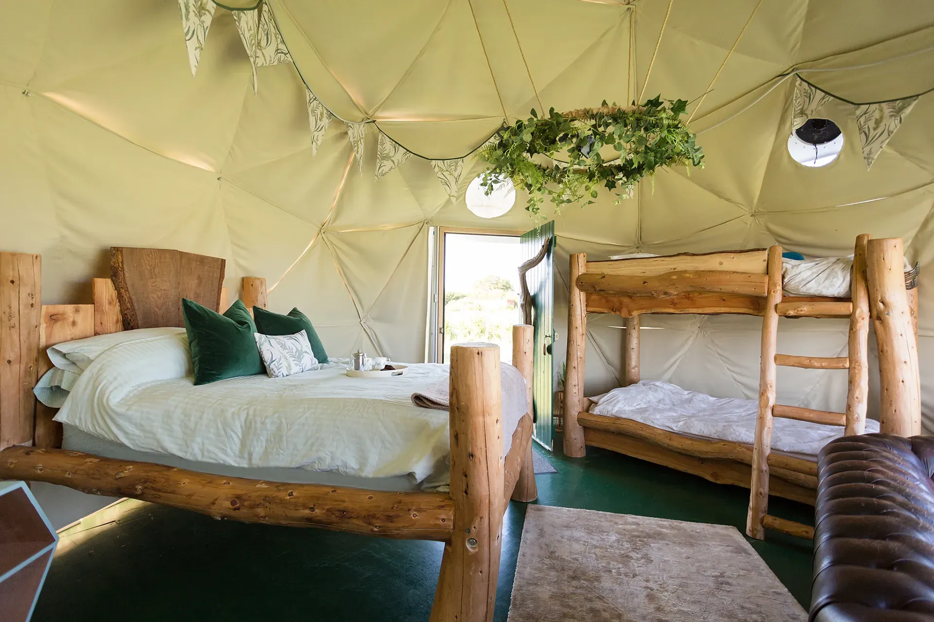 A bedroom in a dome with a bed and bunk beds.