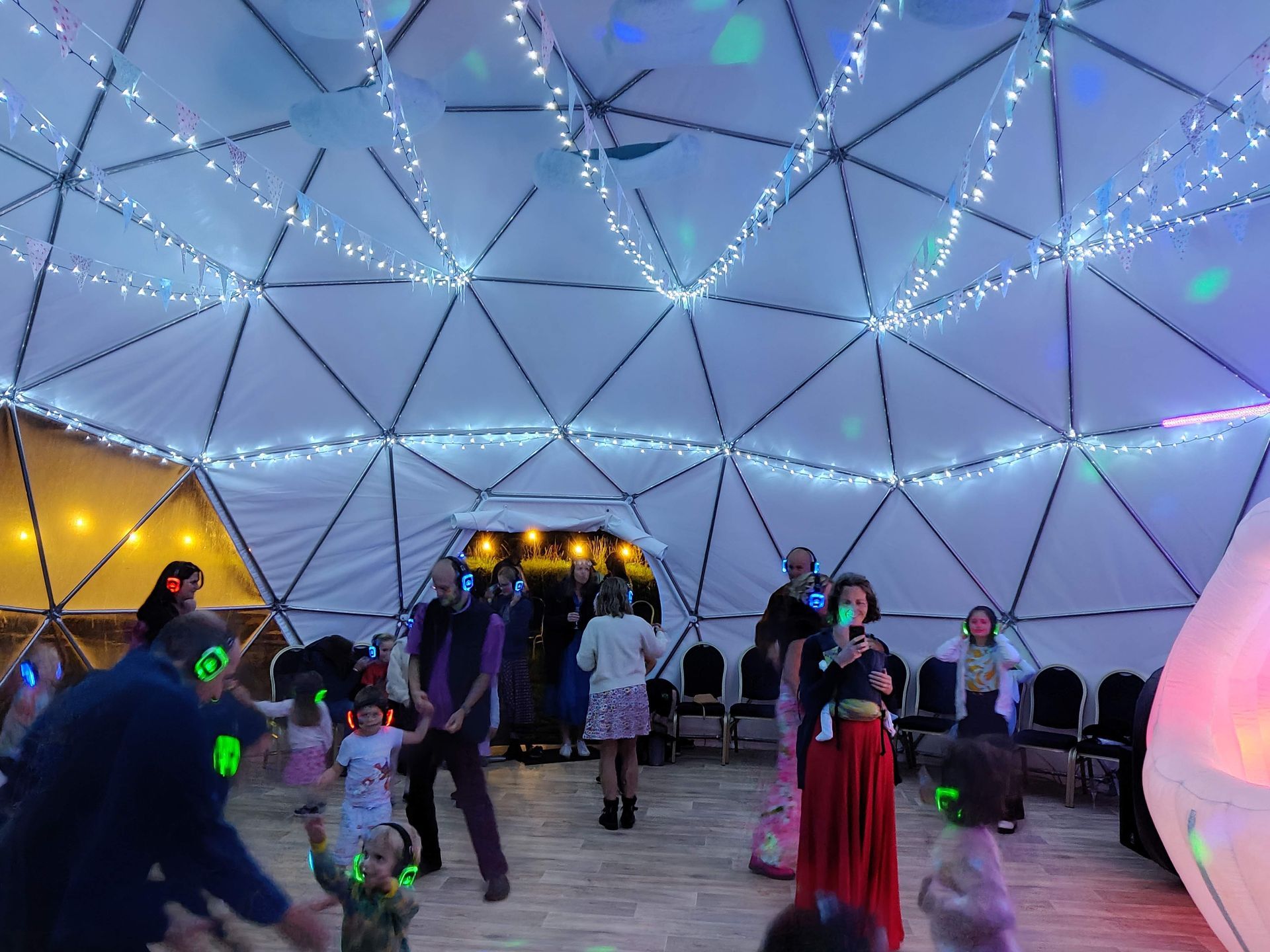 People in a dome having a party with silent disco headphones on