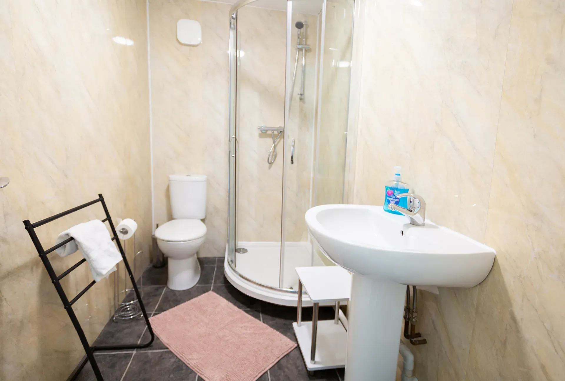 A bathroom with a toilet , sink , and shower stall.