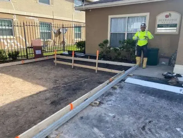 Construction worker near building with concrete forms, preparing for pouring concrete.