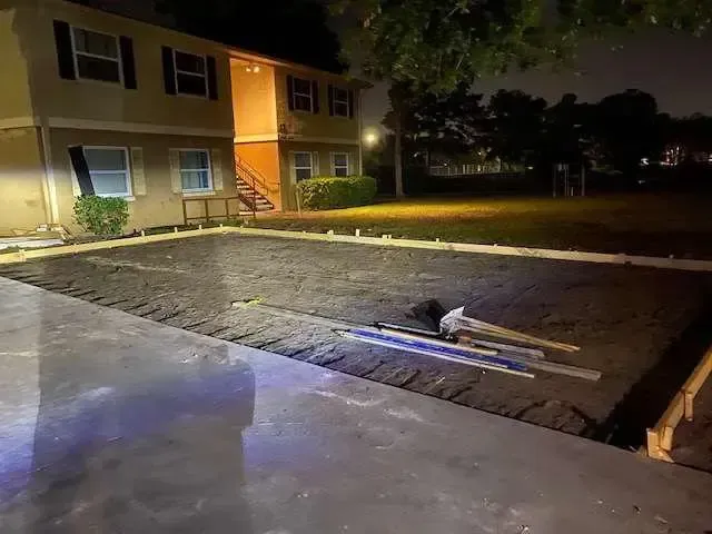 Concrete slab pouring at night in front of an apartment building.