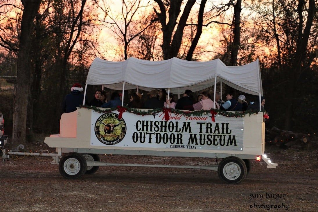 Windmill and log cabin decorated with Christmas lights at night.