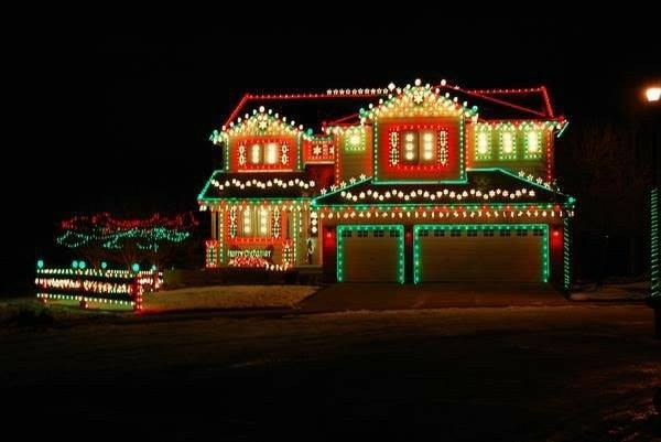 House decorated with green and red Christmas lights, illuminated at night.