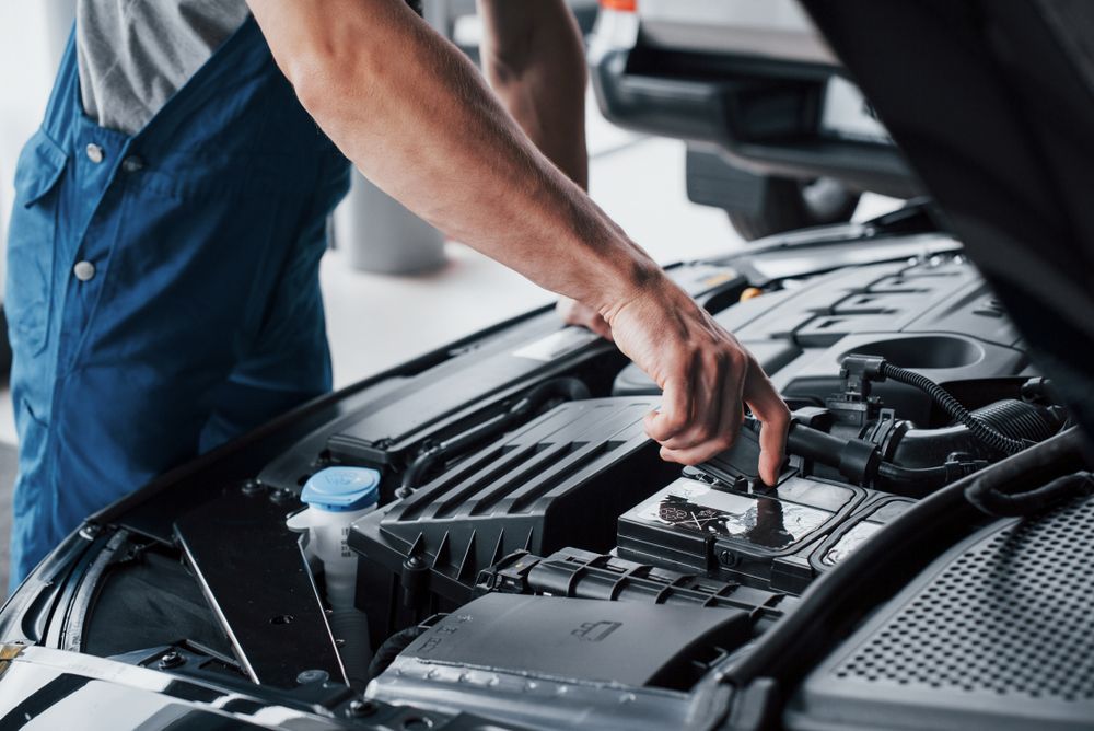 Mechanic in Blue Overalls Working on a Car Engine in a Garage — Morty's Mechanical In Garbutt, QLD