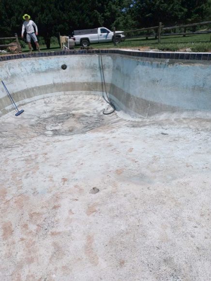 An empty swimming pool with a truck parked in the background
