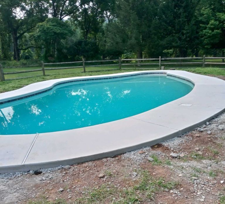 A large swimming pool with a fence in the background