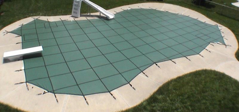 A swimming pool with a green cover on it