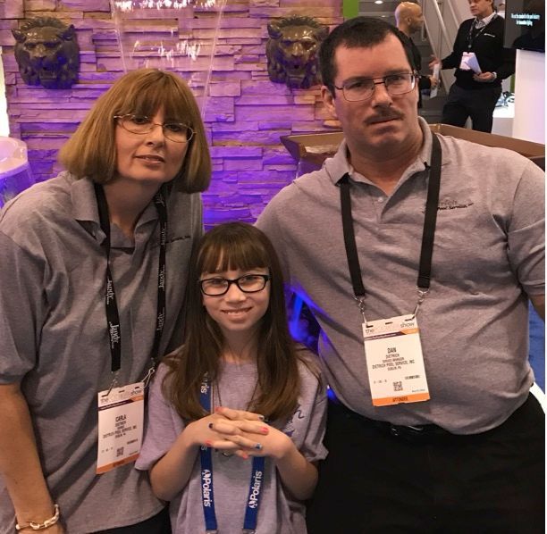 A man and two women pose for a picture with a girl wearing glasses